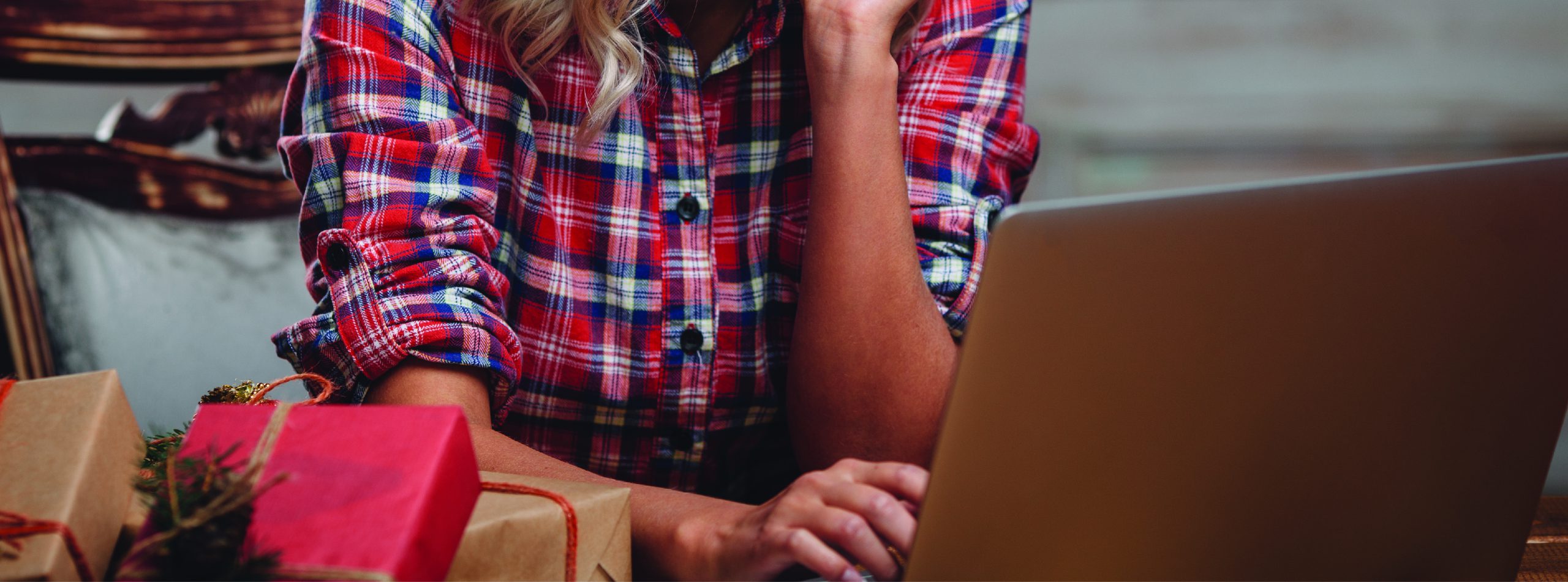 person on the computer with gifts next to them